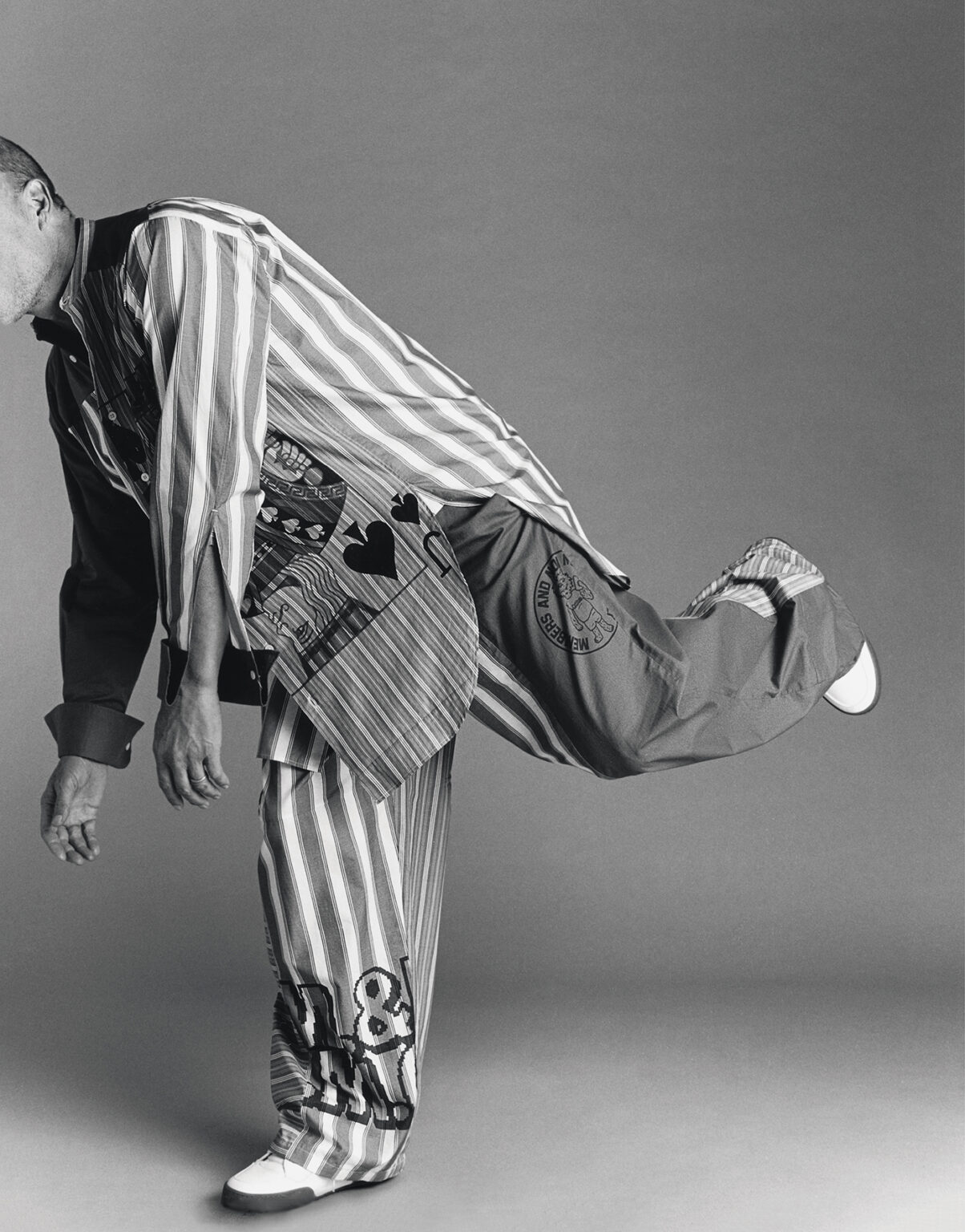FANTASTIC MAN - WOODY was born in Midland, Texas, on 23 July 1961, which was a Sunday. Here, he is wearing a striped patchwork cotton oversized shirt and matching trousers, with white faux-leather lace-up sneakers with rubber soles.